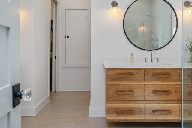 bathroom with tile patterned floors, a shower with door, and vanity