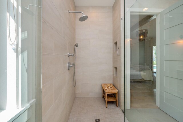 bathroom with a tile shower, tile walls, and tile patterned floors