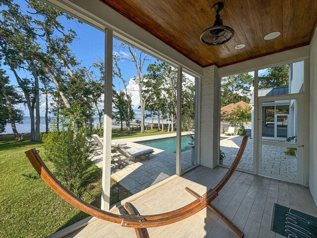 unfurnished sunroom featuring wood ceiling and a water view