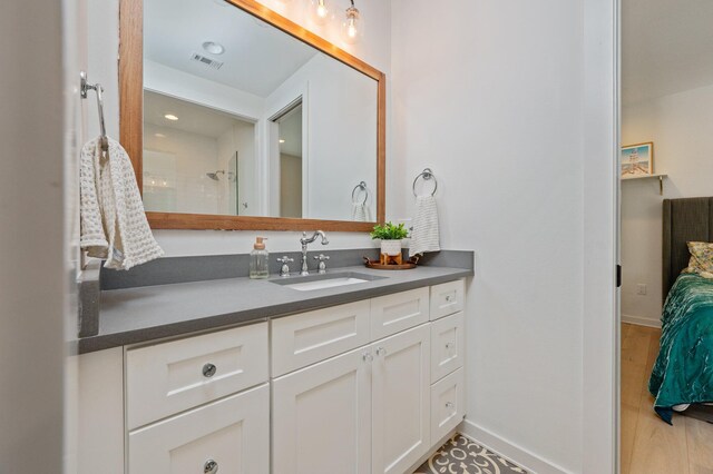 bathroom with vanity, a shower, and hardwood / wood-style floors