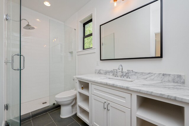 bathroom with tile patterned flooring, walk in shower, vanity, and toilet