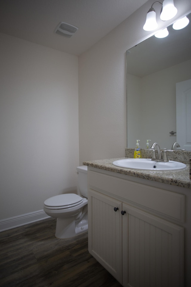 bathroom with hardwood / wood-style flooring, vanity, and toilet