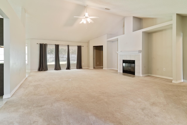 unfurnished living room with high vaulted ceiling, a tile fireplace, light colored carpet, and ceiling fan