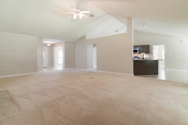 unfurnished living room featuring high vaulted ceiling, light carpet, and ceiling fan