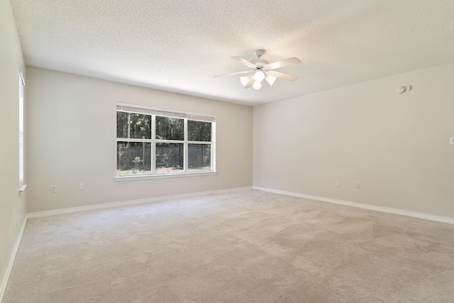 carpeted spare room with a textured ceiling and ceiling fan