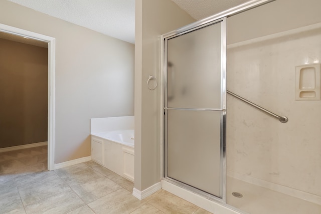 bathroom with independent shower and bath, a textured ceiling, and tile patterned flooring