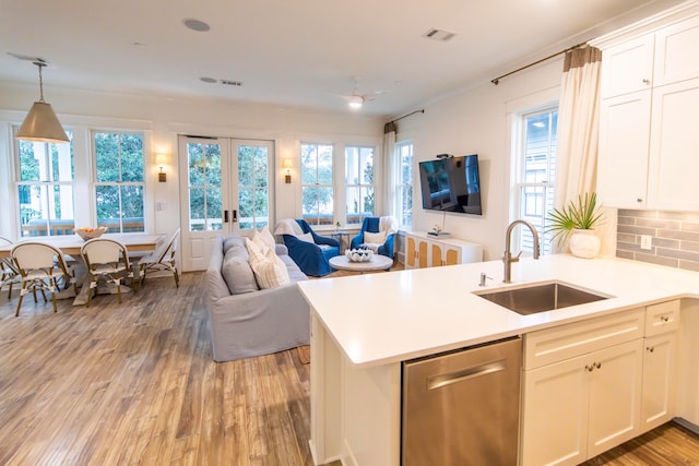 kitchen featuring white cabinets, sink, kitchen peninsula, and stainless steel dishwasher