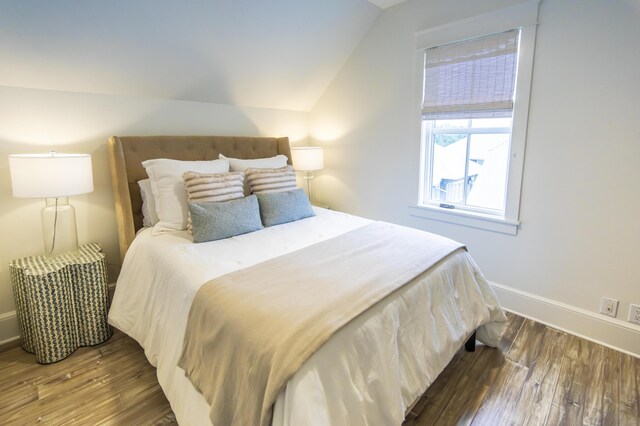 bedroom with vaulted ceiling and hardwood / wood-style floors