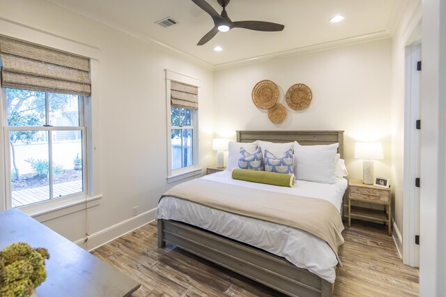 bedroom with crown molding, ceiling fan, and light hardwood / wood-style flooring