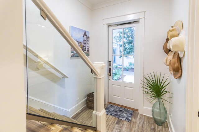 foyer entrance with light hardwood / wood-style flooring and crown molding