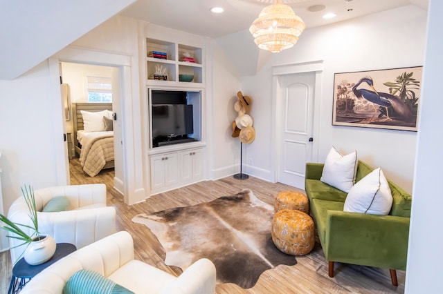 living room featuring a notable chandelier and light wood-type flooring