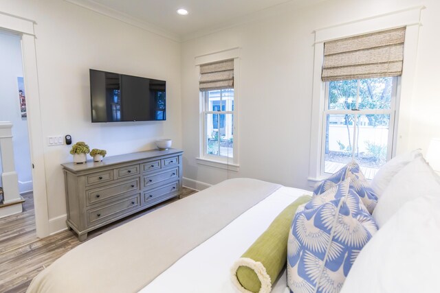 bedroom featuring ornamental molding and light hardwood / wood-style floors