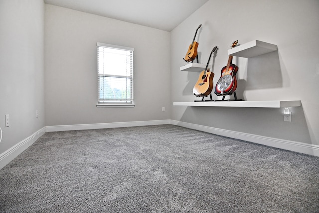 carpeted empty room with vaulted ceiling