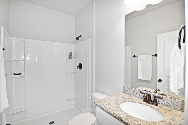 bathroom featuring walk in shower, vanity, and toilet