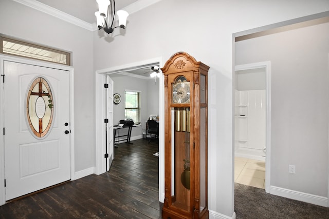 foyer entrance with dark hardwood / wood-style flooring, ceiling fan with notable chandelier, and crown molding