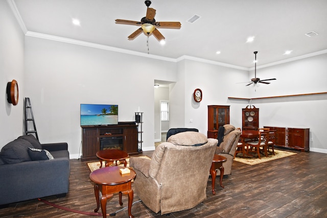 living room with ornamental molding, ceiling fan, and dark wood-type flooring