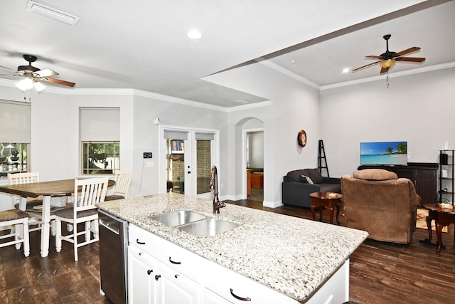 kitchen featuring white cabinets, ceiling fan, a center island with sink, and sink