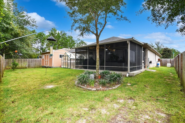 view of yard featuring a sunroom and a storage unit