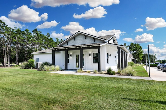 view of front of home with central AC unit, a front lawn, and covered porch