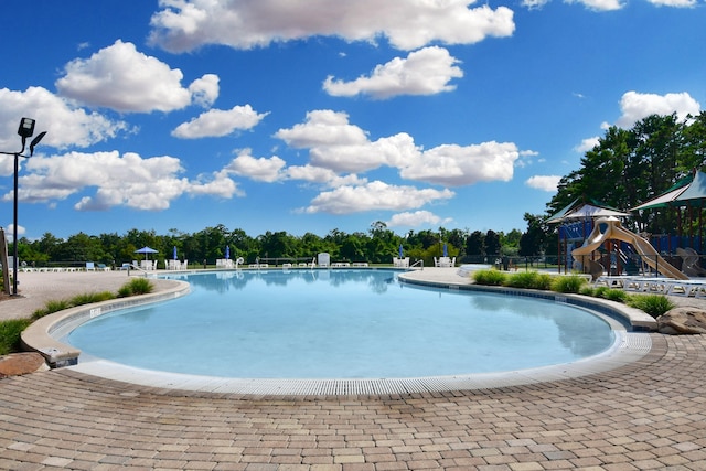 view of swimming pool featuring a playground