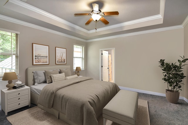 bedroom with ceiling fan, a tray ceiling, connected bathroom, and ornamental molding