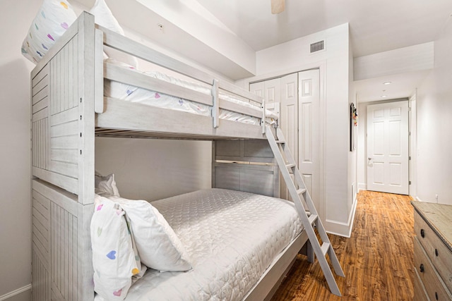 bedroom with dark hardwood / wood-style floors, ceiling fan, and a closet