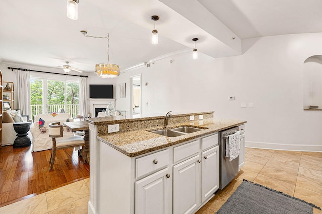 kitchen with light wood-type flooring, dishwasher, sink, white cabinets, and decorative light fixtures