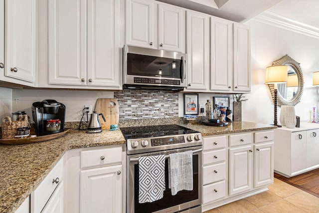 kitchen featuring light wood-type flooring, white cabinetry, appliances with stainless steel finishes, crown molding, and light stone countertops