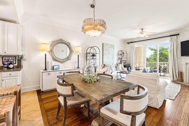 dining room featuring ceiling fan with notable chandelier, light wood-type flooring, and ornamental molding