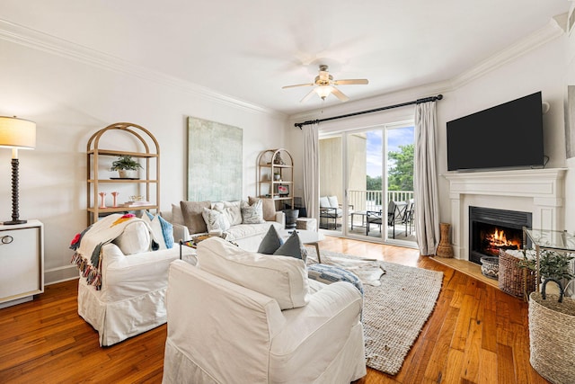 living room with ornamental molding, ceiling fan, and hardwood / wood-style flooring