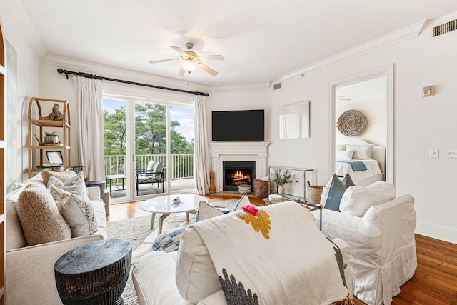 living room featuring ornamental molding, ceiling fan, and hardwood / wood-style floors