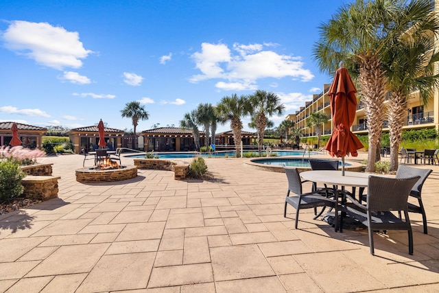 view of patio with a community pool and an outdoor fire pit