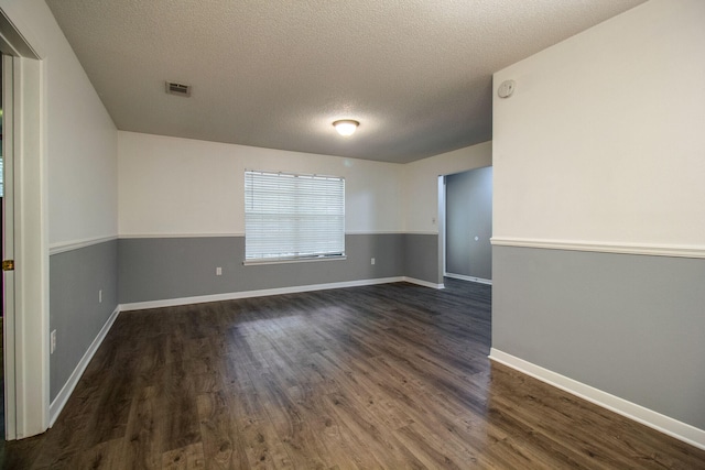 unfurnished room with dark hardwood / wood-style flooring and a textured ceiling