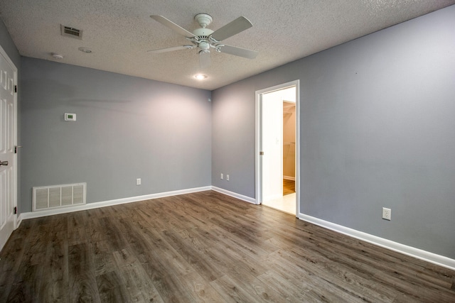 empty room with ceiling fan, wood-type flooring, and a textured ceiling