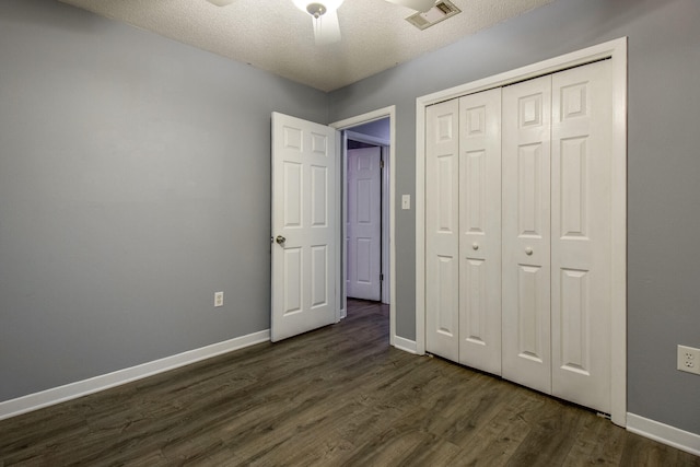 unfurnished bedroom featuring a textured ceiling, ceiling fan, a closet, and dark hardwood / wood-style floors