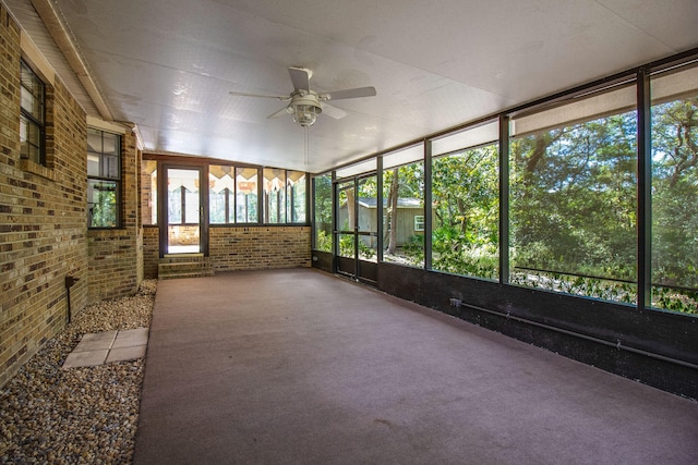 unfurnished sunroom with ceiling fan