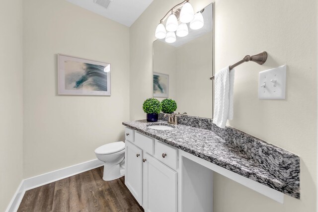 bathroom with wood-type flooring, vanity, and toilet