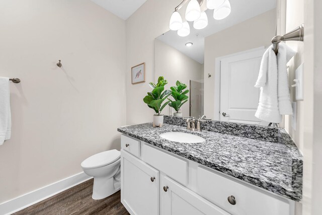 bathroom with vanity, hardwood / wood-style floors, and toilet