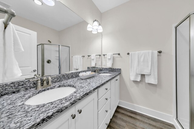 bathroom featuring walk in shower, vanity, and hardwood / wood-style floors