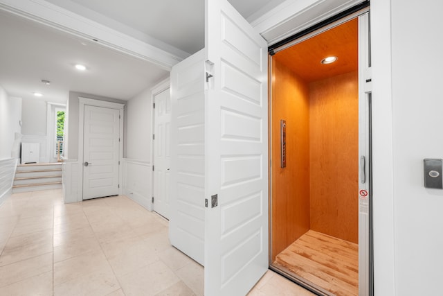 corridor with elevator and light tile patterned floors