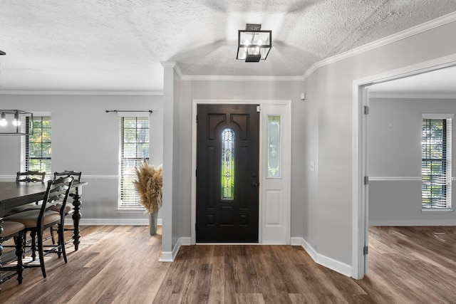 entryway with a textured ceiling, dark hardwood / wood-style floors, and crown molding