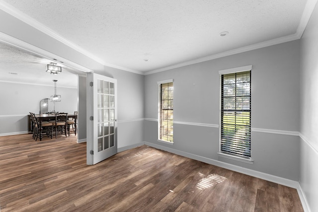 spare room featuring a textured ceiling, crown molding, and dark wood-type flooring