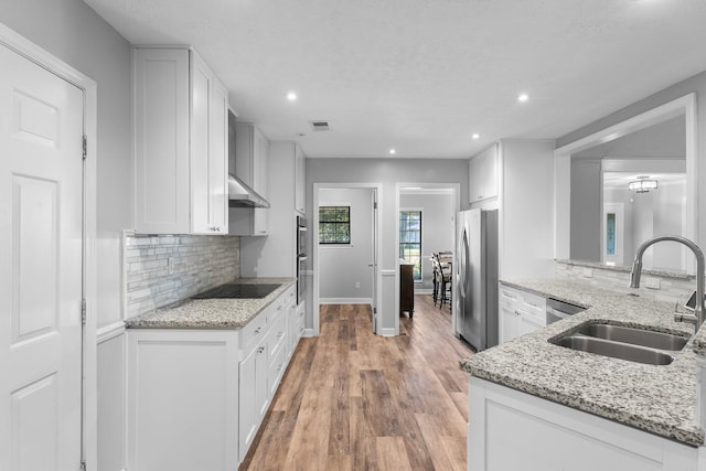 kitchen with appliances with stainless steel finishes, sink, and white cabinetry