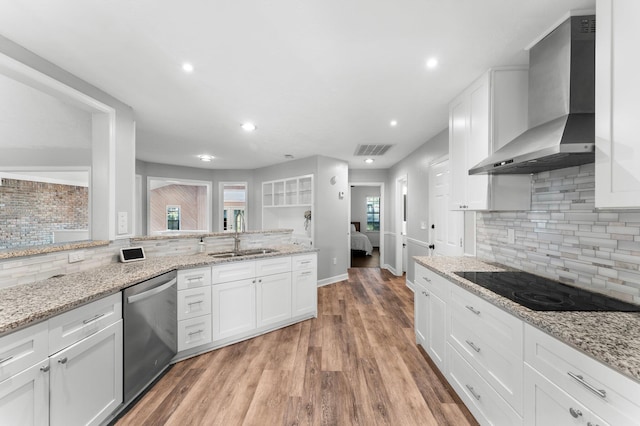 kitchen with dishwasher, sink, wall chimney range hood, and white cabinets