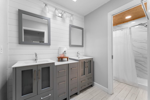 bathroom with wood-type flooring, vanity, wood walls, and walk in shower