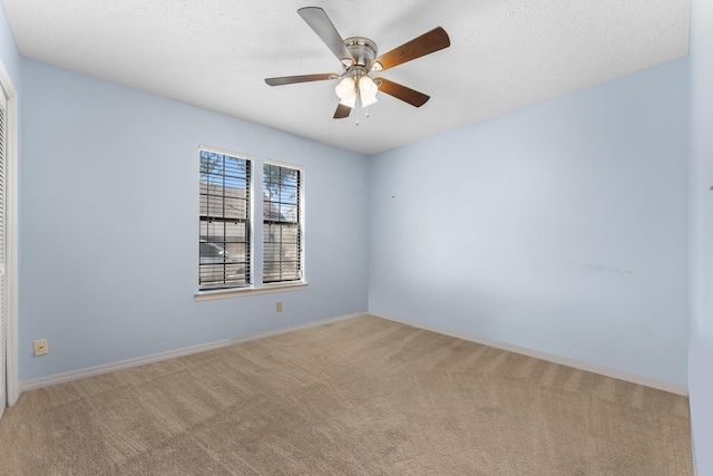 carpeted empty room featuring ceiling fan and a textured ceiling