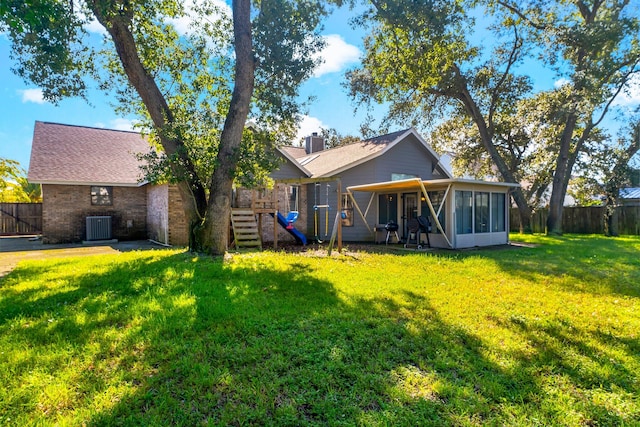 back of house with cooling unit, a yard, and a sunroom