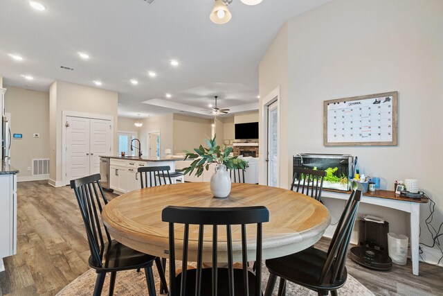 dining room featuring light hardwood / wood-style floors, sink, and ceiling fan