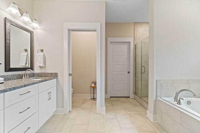 full bathroom with vanity, toilet, plus walk in shower, and tile patterned floors