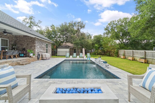 view of pool featuring ceiling fan, a yard, a patio, and pool water feature